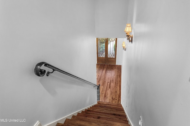 stairway with wood-type flooring and french doors