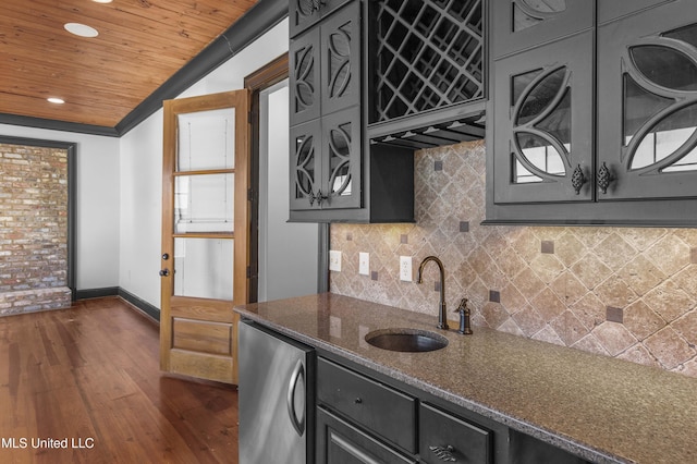 kitchen with dark stone counters, crown molding, sink, dark hardwood / wood-style floors, and stainless steel refrigerator