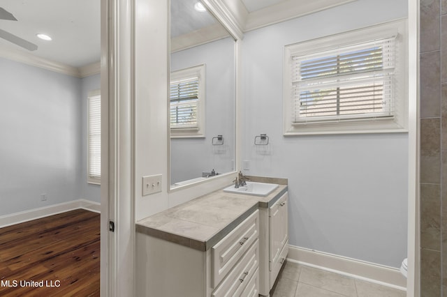 bathroom with hardwood / wood-style floors, vanity, ornamental molding, and a healthy amount of sunlight