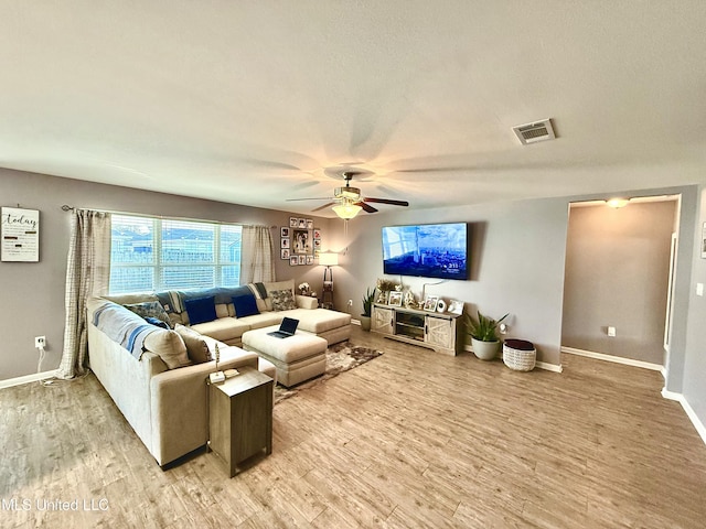 living room featuring ceiling fan and light hardwood / wood-style flooring