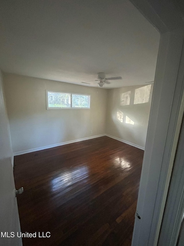 empty room featuring dark hardwood / wood-style flooring and ceiling fan