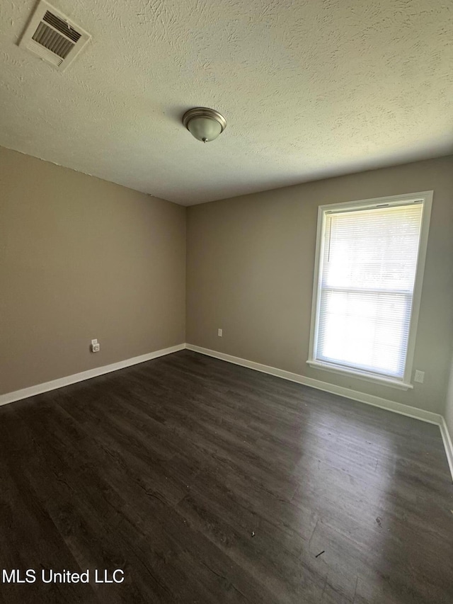 1010 Deryll St, Jackson, MS 39212 - unfurnished room with dark wood-type flooring, baseboards, and a textured ceiling