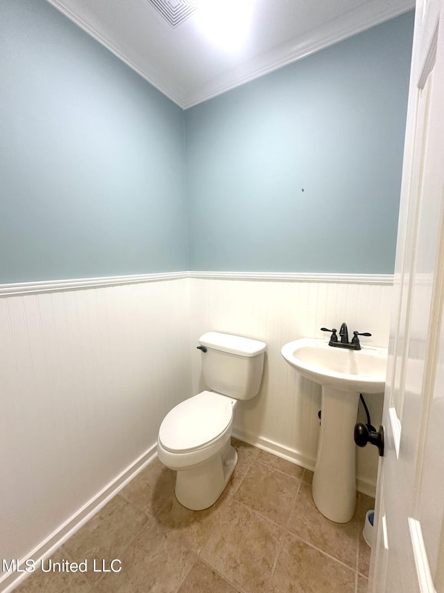 bathroom with ornamental molding, sink, toilet, and tile patterned floors