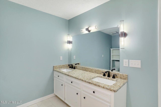 bathroom featuring vanity, a textured ceiling, and tile patterned flooring