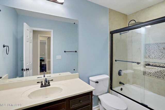 full bathroom featuring toilet, vanity, and shower / bath combination with glass door