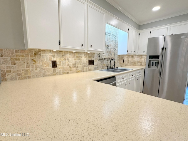 kitchen featuring tasteful backsplash, appliances with stainless steel finishes, white cabinetry, crown molding, and sink