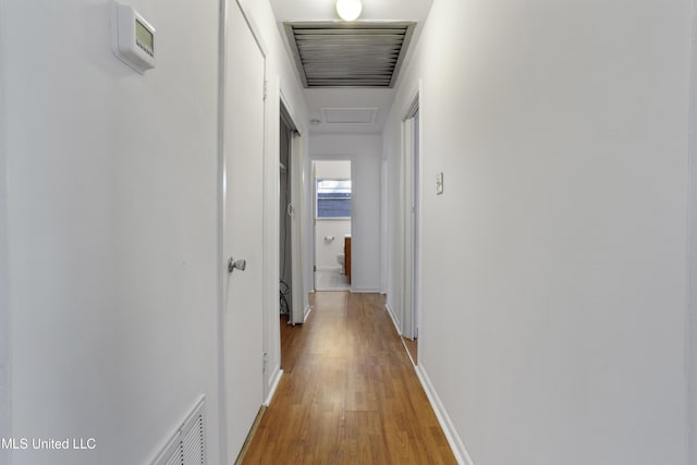 corridor with hardwood / wood-style flooring