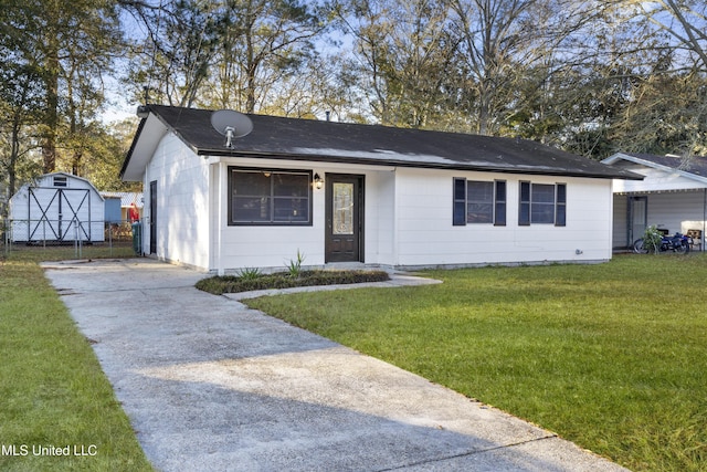 single story home featuring a front yard and a shed