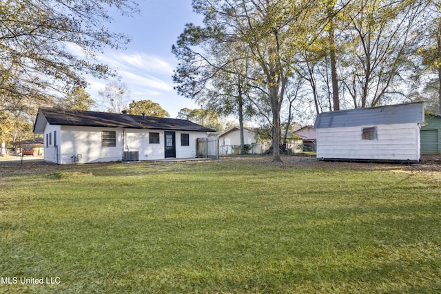 view of yard featuring central AC unit and a shed