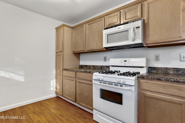 kitchen with white appliances and light hardwood / wood-style floors