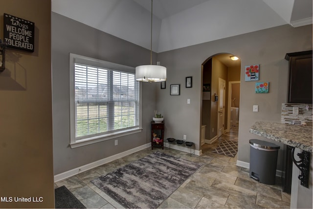 dining space featuring arched walkways and baseboards