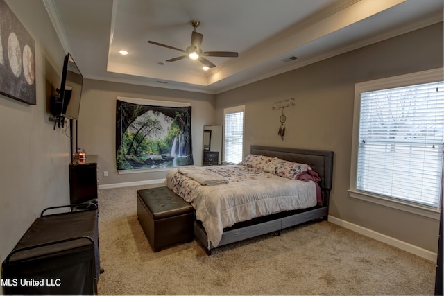 bedroom with carpet floors, a tray ceiling, visible vents, and baseboards