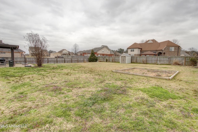 view of yard featuring an outbuilding, a fenced backyard, and a storage shed