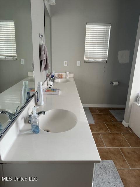 bathroom featuring tile patterned floors, vanity, and a bath