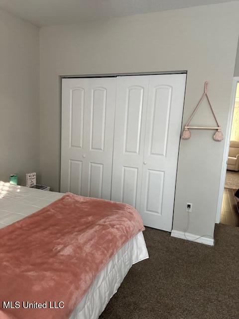 bedroom featuring a closet and dark carpet