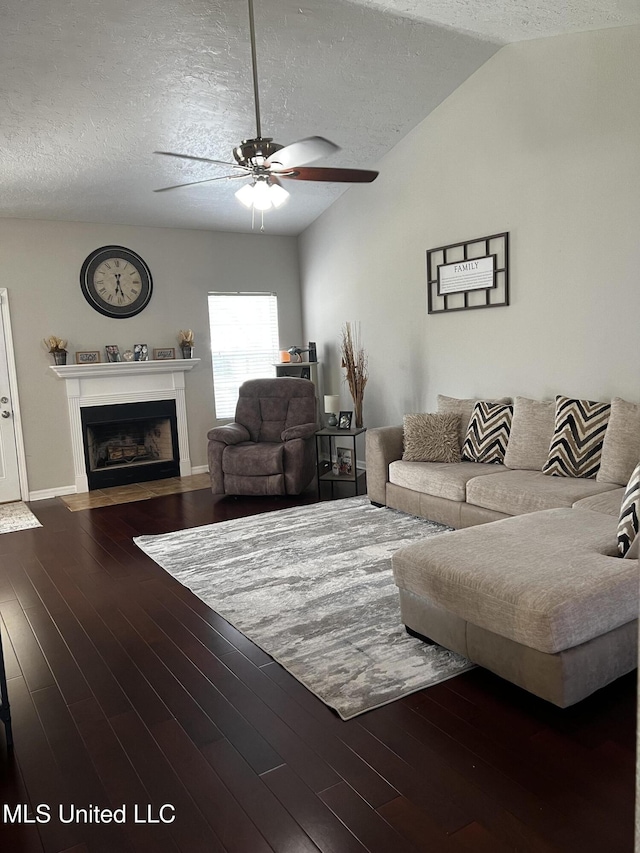 living room with dark hardwood / wood-style floors, ceiling fan, a textured ceiling, and vaulted ceiling