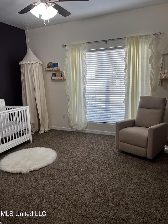 carpeted bedroom featuring ceiling fan and a nursery area