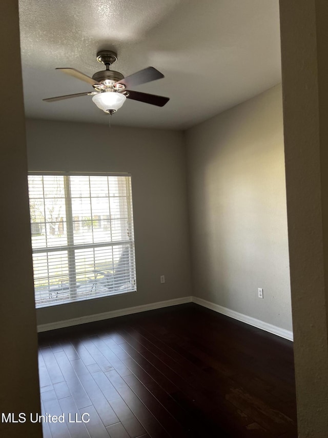 spare room with a textured ceiling, dark hardwood / wood-style floors, and ceiling fan