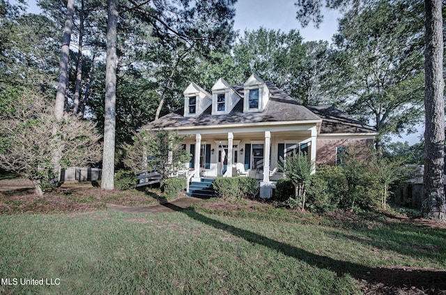 new england style home with a porch and a front yard