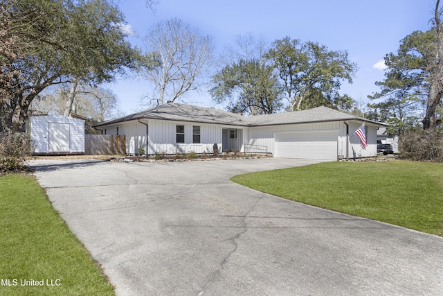 ranch-style house with a shed, a garage, fence, driveway, and a front lawn