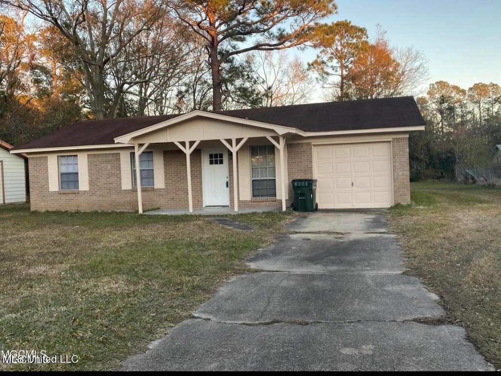 single story home featuring a garage and a front lawn