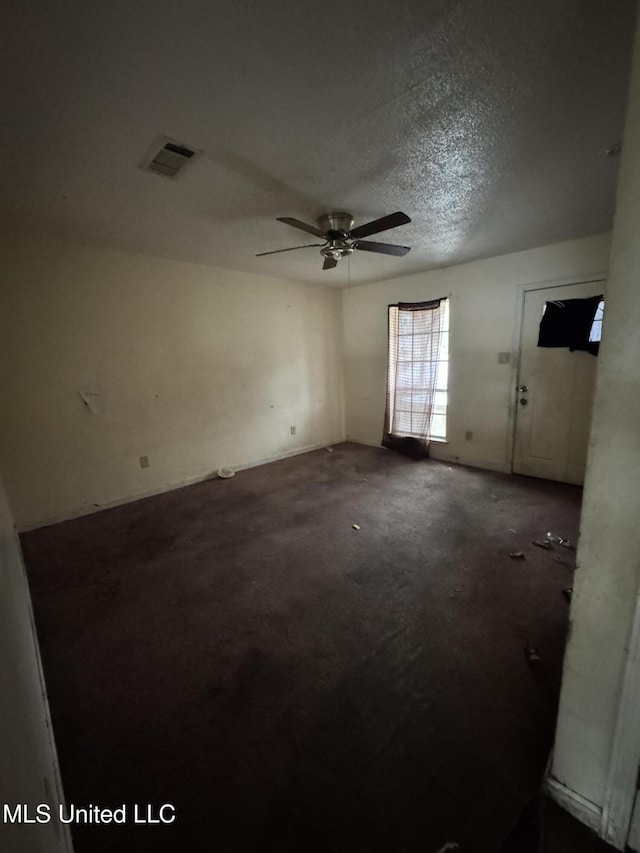 unfurnished room featuring ceiling fan and a textured ceiling