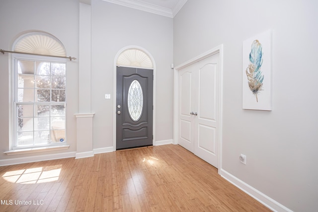 entryway with crown molding and light wood-type flooring