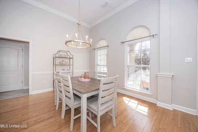 dining area with a notable chandelier, light hardwood / wood-style flooring, and ornamental molding