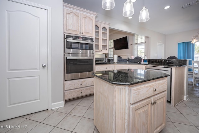 kitchen with hanging light fixtures, a kitchen island, light tile patterned floors, and appliances with stainless steel finishes