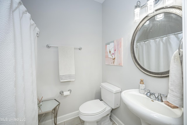 bathroom with toilet, tile patterned flooring, and sink