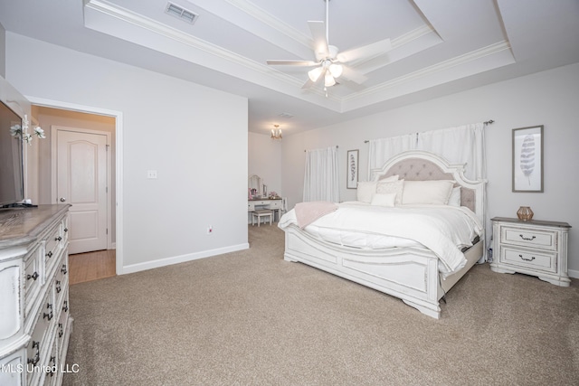 carpeted bedroom featuring crown molding, ceiling fan, and a tray ceiling