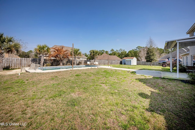 view of yard with a shed, a fenced in pool, and a patio area