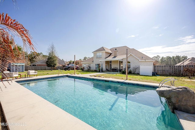 view of swimming pool featuring a yard