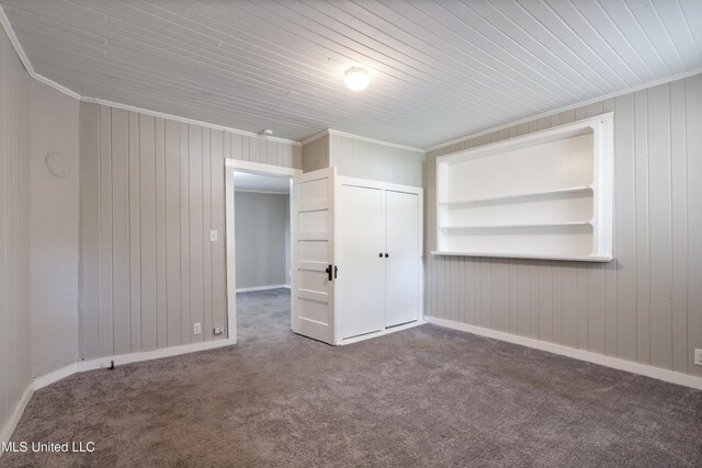 777 W Main St, Senatobia, MS 38668 - empty room with carpet floors, wood walls, ornamental molding, and wood ceiling
