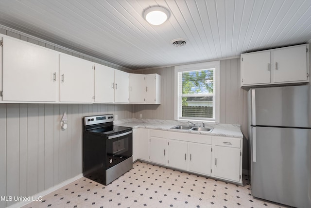 777 W Main St, Senatobia, MS 38668 - kitchen featuring stainless steel appliances, white cabinets, light floors, wood ceiling, and wood walls