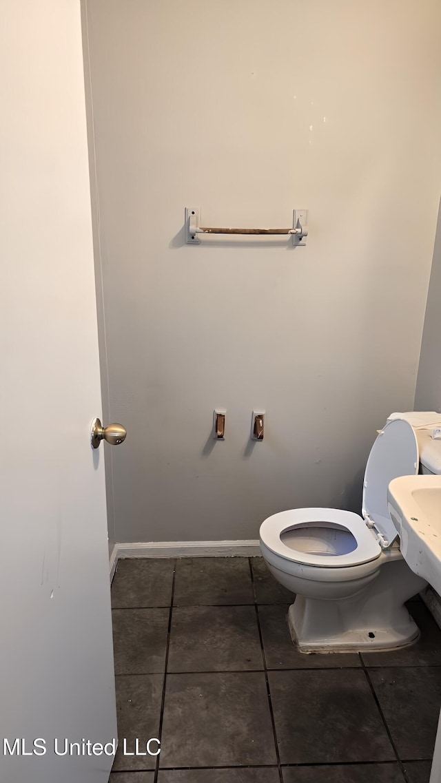 bathroom featuring toilet, baseboards, and tile patterned floors