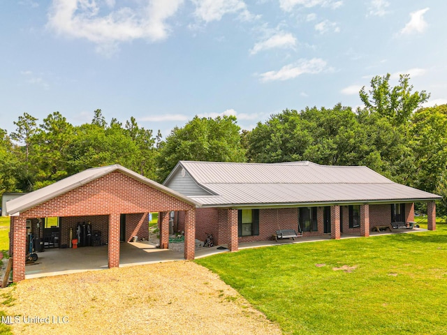 ranch-style home with metal roof, brick siding, a front yard, and driveway