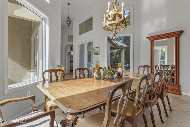 7395 Live Oak Way, Pass Christian, MS 39571 - dining room featuring light tile patterned floors, a towering ceiling, a chandelier, baseboards, and french doors