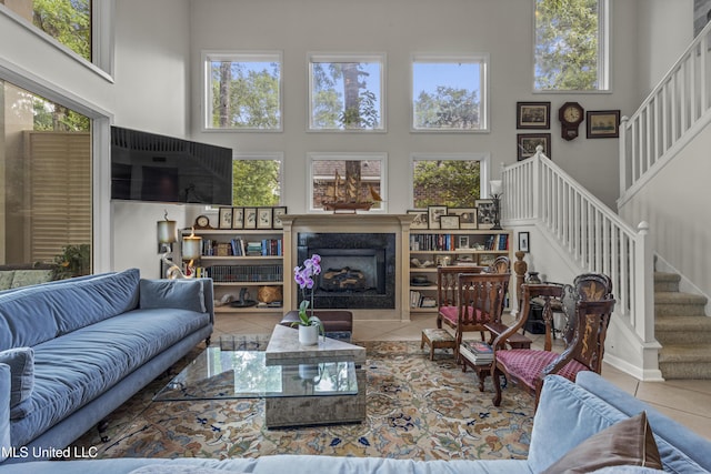 7395 Live Oak Way, Pass Christian, MS 39571 - tiled living area featuring a towering ceiling, stairs, and a premium fireplace