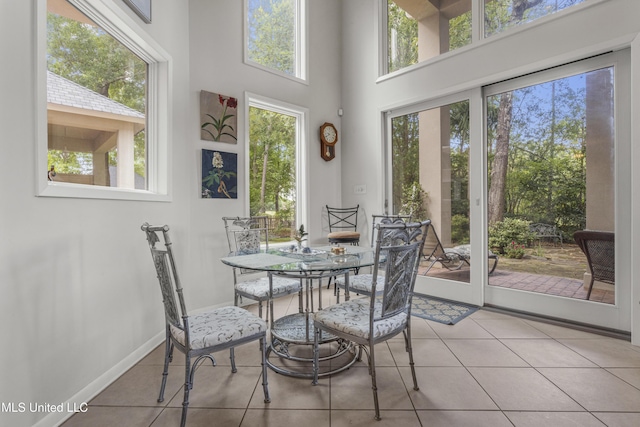 7395 Live Oak Way, Pass Christian, MS 39571 - tiled dining space featuring plenty of natural light, a towering ceiling, and baseboards