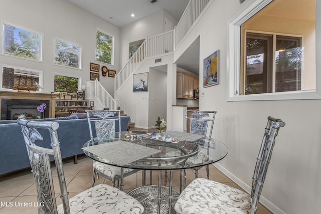 7395 Live Oak Way, Pass Christian, MS 39571 - dining room with a high ceiling, light tile patterned floors, stairs, baseboards, and a high end fireplace