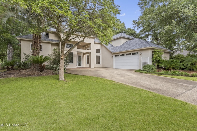 7395 Live Oak Way, Pass Christian, MS 39571 - mid-century modern home with stucco siding, a garage, a front yard, and concrete driveway