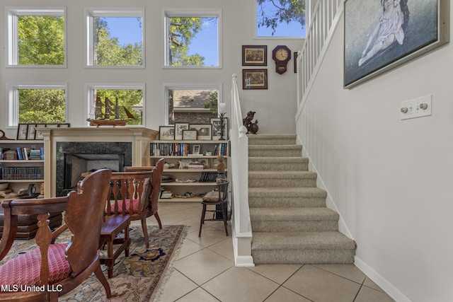 7395 Live Oak Way, Pass Christian, MS 39571 - stairs with a towering ceiling, tile patterned floors, a premium fireplace, and baseboards