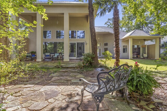 7395 Live Oak Way, Pass Christian, MS 39571 - rear view of house with stucco siding, a patio area, and an outdoor hangout area
