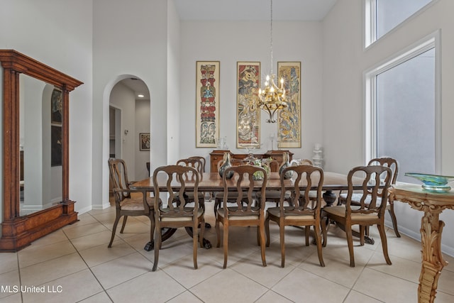 7395 Live Oak Way, Pass Christian, MS 39571 - dining area with a high ceiling, light tile patterned floors, arched walkways, a chandelier, and baseboards