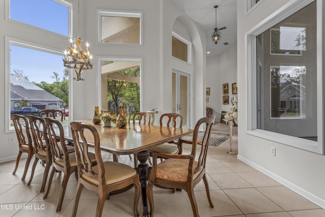7395 Live Oak Way, Pass Christian, MS 39571 - dining area featuring a high ceiling, light tile patterned floors, a chandelier, baseboards, and french doors