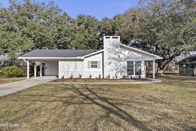 mid-century inspired home featuring concrete driveway, a chimney, an attached carport, a front lawn, and brick siding