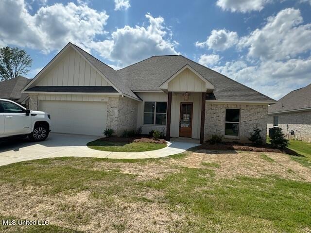 317 Willow Way Unit 158, Canton, MS 39046 - view of front of property with concrete driveway, board and batten siding, a front yard, an attached garage, and brick siding