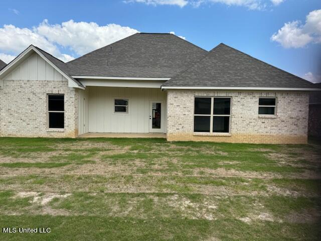317 Willow Way Unit 158, Canton, MS 39046 - rear view of house featuring brick siding, board and batten siding, a shingled roof, and a yard