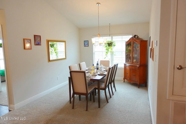 dining space featuring a notable chandelier, light colored carpet, visible vents, baseboards, and vaulted ceiling